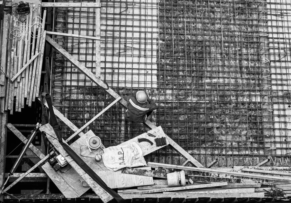 High angle view of a worker at a construction site captured in black and white.